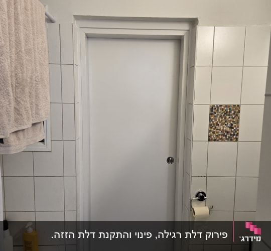 דלת פנים לבנה מותקנת בחדר רחצה מחופה אריחים